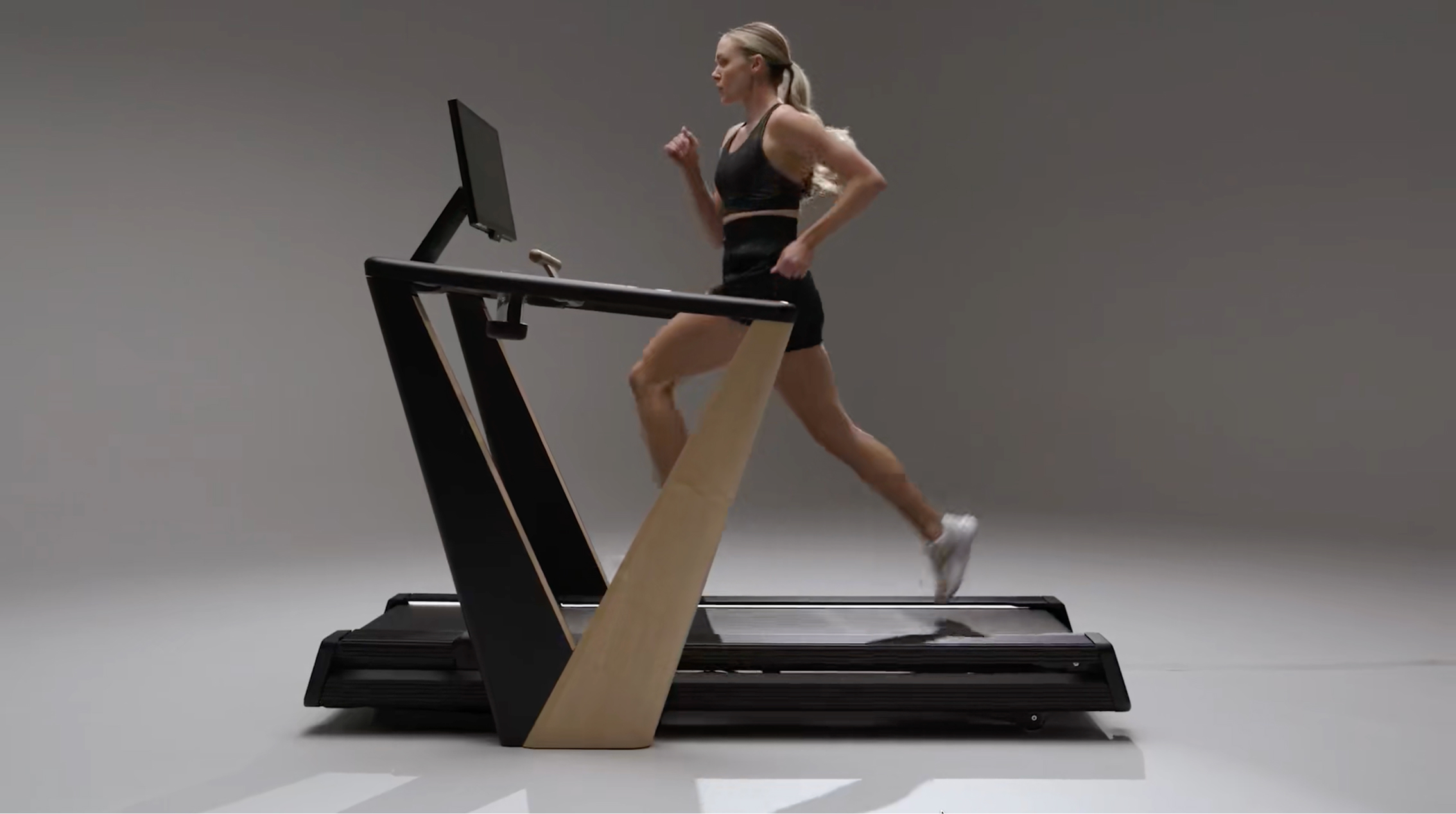 Runner using an iFIT treadmill in a studio setting.